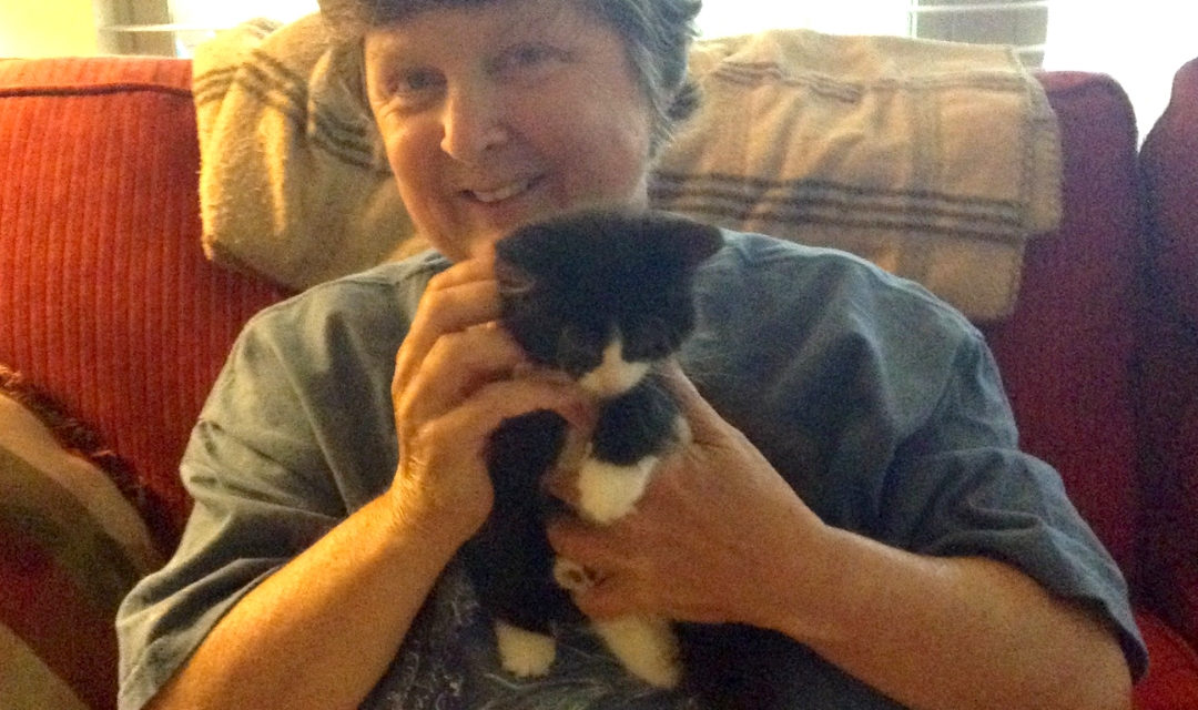 Owner Deborah Murphy Holding A Black And White Kitten