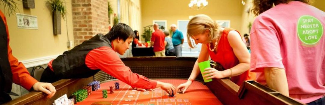 Catsino Dealer and Guest Leaning Over Casino Table To Pick Up Chips